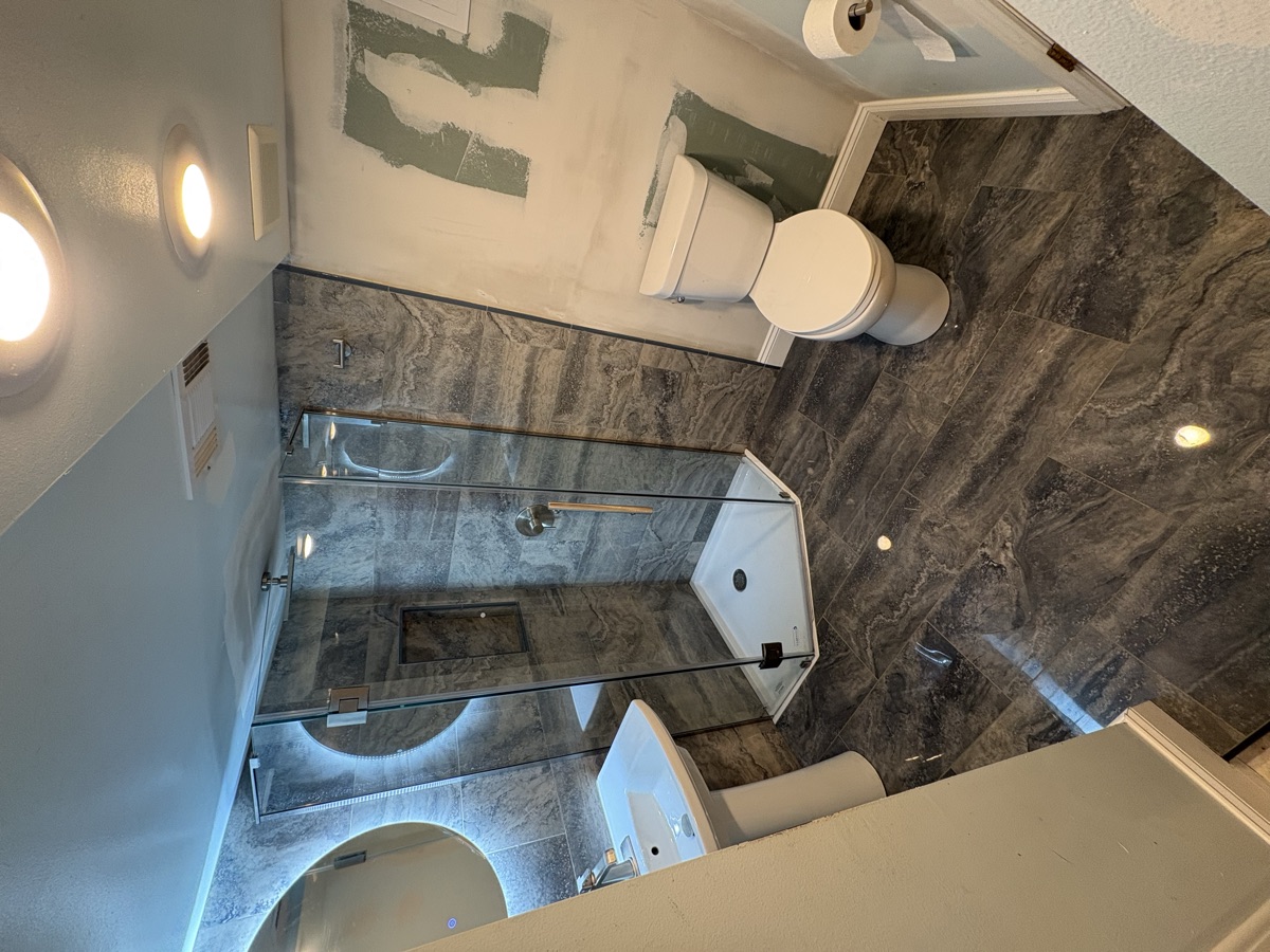 Bathroom after remodel - marble tile, glass shower door, modern finishes