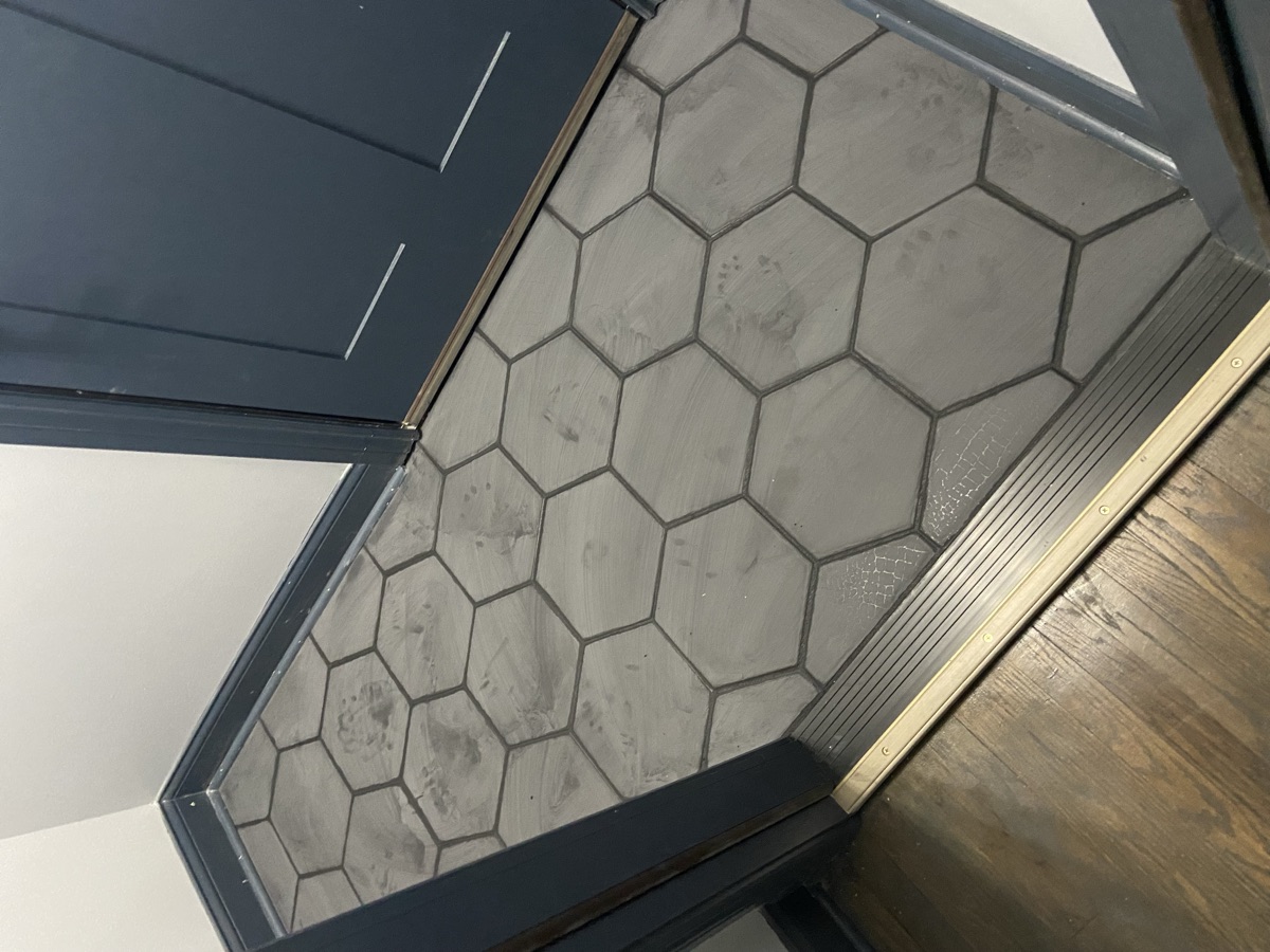 Hexagonal tile entryway with dark trim by ECV Handyman Services